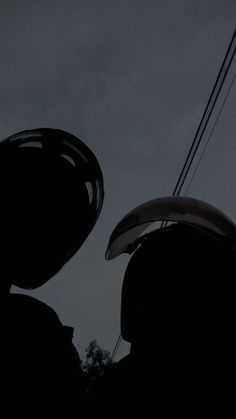 the silhouette of a person holding a kite in their hands and looking up at the sky