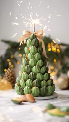 a green christmas tree made out of bananas and nuts with sparklers in the background