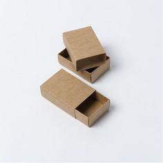 two cardboard boxes sitting side by side on a white surface with one open and the other closed