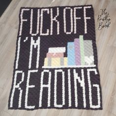 a crocheted rug that says fuk off it's reading