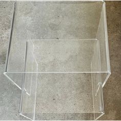 a clear acrylic box sitting on the ground