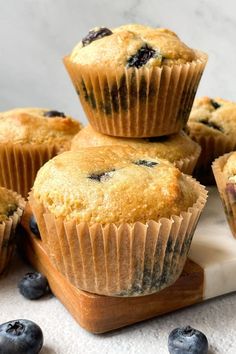 blueberry muffins stacked on top of each other with fresh blueberries around them