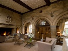 a large living room with high ceilings and stone walls