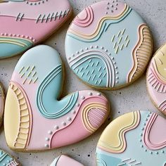 decorated cookies with pastel colors are arranged on a table