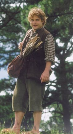 a young man is standing in the grass