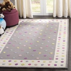 a gray rug with multicolored polka dots on it in front of a window