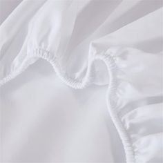 white bedding with ruffles on the top and bottom sheets, close up