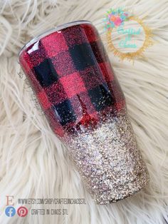 a red and black plaid tumbler with glitter on it