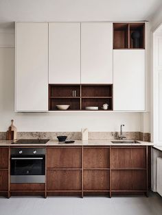 a kitchen with wooden cabinets and white walls