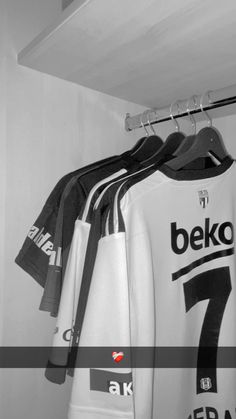 several soccer jerseys hanging on a rack in a closet with the name beko printed on them