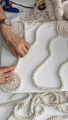 two hands are working on rope with scissors