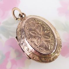 Ornately engraved floral motif designs decorate both sides of this antique 10k solid yellow gold locket pendant. The fully engraved floral reversible pendant features detailed linework, scrolling and floral details, which differs on each side. The locket opens with the help of two tiny knobs and closes securely with a light snap. Inside you will find both original frames attached to glass inserts. The locket tested as 10k gold in three locations (no hallmark). The large added bail at top is gold filled. This antique lovingly aged piece is in very good condition for its turn-of-the-century age. It has some expected surface wear and a few tiny dings to its outer shell. There are two dark lines where the trim was joined on each panel. Please see photos for condition and detailed measurements Antique Medallion Locket Necklace Stamped 14k, Vintage Etched Rose Gold Jewelry, Engraved Rose Gold Round Pendant Locket Necklace, Engraved Rose Gold Pendant Locket Necklace, Engraved Rose Gold Locket Necklace With Round Pendant, Vintage Rose Gold Etched Jewelry, Ornate Yellow Gold Medallion Locket Necklace, Victorian Engraved Rose Gold Locket Necklace, Formal Rose Gold Engraved Locket Necklace