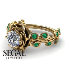 a gold ring with green stones and leaves on the side, in front of a white background