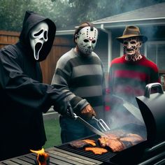 three people wearing masks grilling meat on a grill with flames in front of them