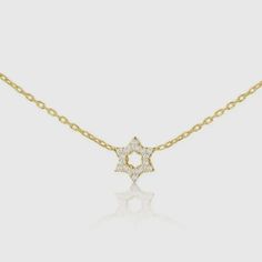 This is a pre-order item and will ship within 7-10 business days. The hint of sparkle, the diamonds and gold lay softly on your chest. This dainty Star of David necklace is ideal for anyone looking to add a pop of sparkle and a pendant full of love, hope, and faith. 14k goldSet with 6 full cut diamonds weighing .06ct total weight 16" chain with 2" extender Choose from white, rose, or yellow gold Star Pendant Size: 1/4" Star Of David Necklace With Single Cut Diamonds, Yellow Gold Star Necklace With Cubic Zirconia, Yellow Gold Star-shaped Cubic Zirconia Necklace, Gold Cubic Zirconia Star Of David Necklace, Diamond Necklace With Star Of David Charm For Gift, Diamond Star Of David Necklace As Gift, Star-shaped Necklace With Single Cut Diamonds For Gift, Star Necklace With Single Cut Diamonds For Gift, Star Shaped Necklace With Single Cut Diamonds For Gift