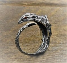 Cool 925 sterling silver adjustable gothic dragon ring, suitable for both men and women. This is a universal snake ring. Stones are inserted into the eyes - cubic zirkonia, any color can be ordered. A ring with a dragon - will decorate you or become a wonderful gift for a loved one. Silver ring in the form of a dragon - personifies the spirit of the coming year. This is a great gift for someone close to you. A gift for the New Year or Christmas, a gift for those born in the year of the Dragon. We invite you to the store of exclusive jewelry handmade in the styles of gothic, steampunk, skull, viking, slavic, norse, amulets, scandinavian, masonic, muslim, engagement, wedding. Personalization possible Material: high quality solid 925 sterling silver  Material to order: gold plated, gold from Adjustable Ring With Dragon Design, Adjustable Gothic Snake Ring As Gift, Adjustable Gothic Snake Ring For Gift, Unique Snake Ring With Dragon Design Gift, Wedding Personalization, Ring Stones, Gothic Dragon, Dragon Ring, Snake Ring