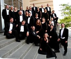 a group of people dressed in black and white posing for a photo on the steps