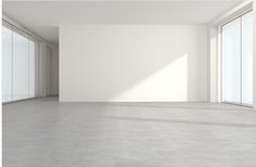 an empty room with white walls and large windows