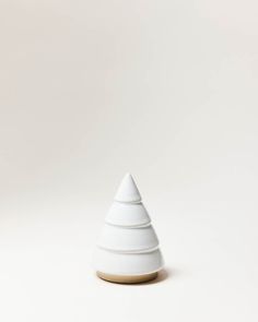 a small white vase sitting on top of a table