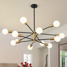 a modern chandelier with eight globe lights in a living room setting, featuring red flowers and white walls