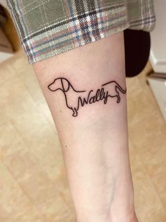 a person with a dog tattoo on their arm that says,'valley'in cursive writing