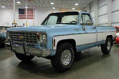 an old blue and white truck parked in a garage