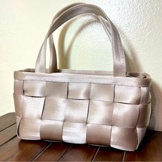 a white purse sitting on top of a wooden table