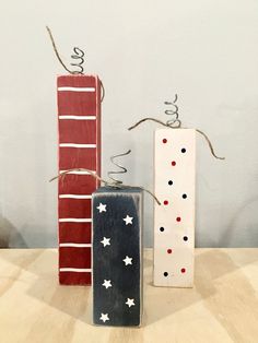 three wooden blocks with red, white and blue designs on them sitting on a table