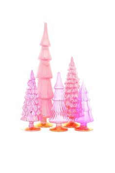 pink and purple plastic christmas trees on gold bases, set against a white back ground