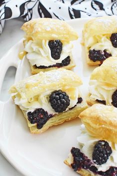 several pastries on a white plate with blackberries