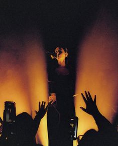 a woman standing on top of a stage surrounded by people