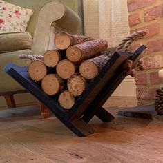 a stack of logs sitting on top of a wooden floor next to a chair and fireplace