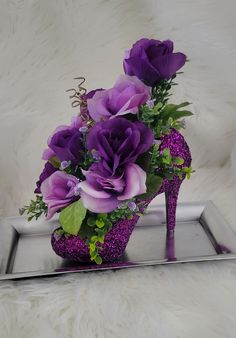 a purple shoe with flowers in it sitting on a tray