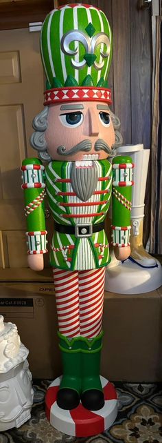 a large green and white nutcracker standing on top of a table