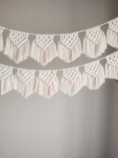 white crocheted tassels hanging from a string on a wall in a room