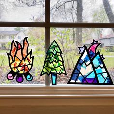 three stained glass trees sitting on top of a window sill