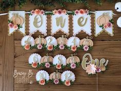 a wooden table topped with lots of cake and cupcakes covered in frosting