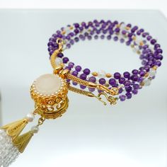 This beautiful necklace set features a multi-style beaded amethyst necklace with a white jade and zircon tassel pendant. The necklace is made up of 81 primary gemstones, with every 9 gemstones grouped and connected by spacer gemstones. The pendant can be detached from the necklace and replaced with any pendant you like, and the necklace can also be worn as a glasses chain. The ancient Chinese believed that the number 9 symbolized eternity, and that surviving 81 tribulations could help a person r Elegant Round Jewelry With 108 Beads, Double Strand Amethyst Gemstone Beads Jewelry, Elegant Round Beads Hand-strung Crystal Necklace, Amethyst Double Strand For Jewelry Making, Elegant Hand-strung Crystal Necklaces With Round Beads, Elegant 108 Beads Jewelry Gift, Elegant Beaded Necklaces With Round Beads For Meditation, Elegant Round Beads Necklaces For Meditation, Elegant Hand-strung Agate Necklace