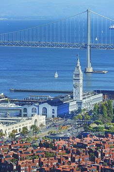 an aerial view of a city with a bridge in the background