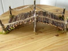 a piece of wood that is sitting on top of a wooden table with sticks attached to it