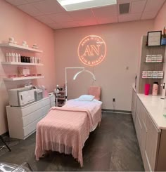 a pink room with a bed, desk and shelves on the wall next to it