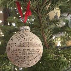 an ornament hanging from a christmas tree decorated with music notes and red ribbon