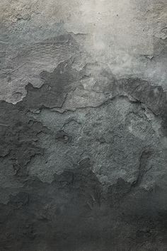 a black and white photo of the surface of a concrete wall with cracks in it