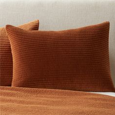 two brown pillows sitting on top of a bed