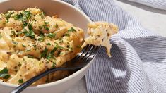 a white bowl filled with macaroni and cheese on top of a blue towel