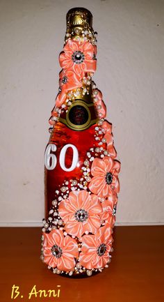 a bottle with flowers on it sitting on a table