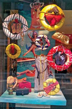 a display in a store window filled with lots of hats and bikinis on mannequins