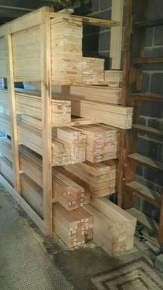 several stacks of wooden boxes stacked on top of each other in a room with brick walls