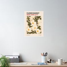 a flower market poster hangs on the wall next to a desk with office supplies and plants