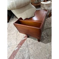 a wooden box sitting on the floor next to a chair